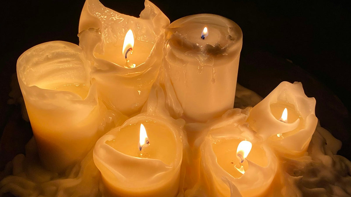 A group of pillar candles, burned down and lit