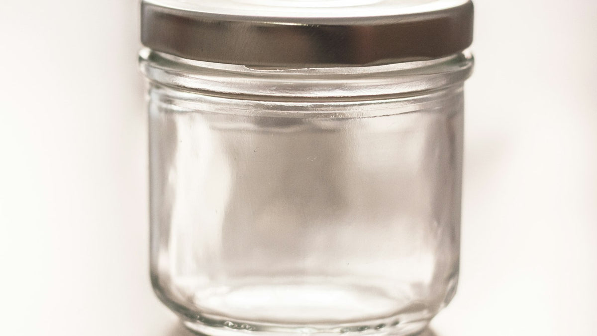 An empty clean glass jar with a metal lid