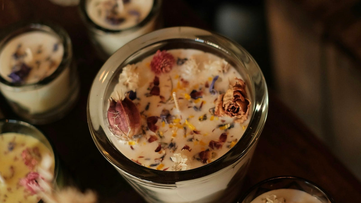 Plant wax candles in glass jars topped with dried flowers