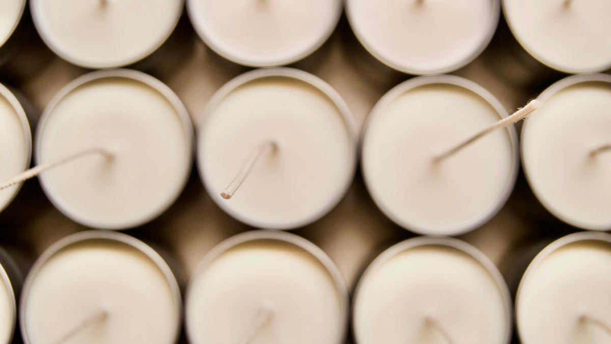 Rows of unlit white tea lights with their wicks showing