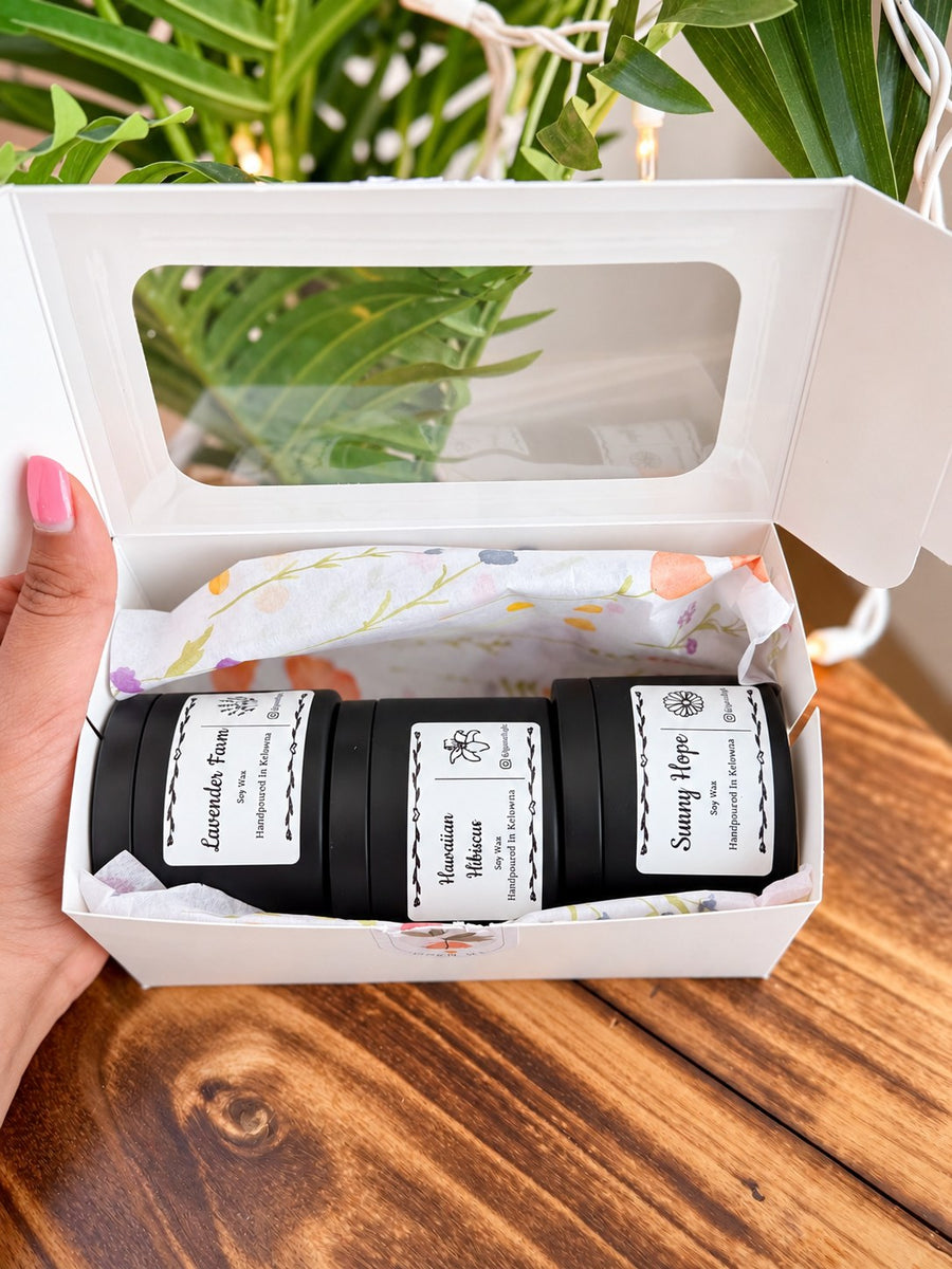 Open Floral Trio gift box showing three labelled tin candles on floral tissue paper