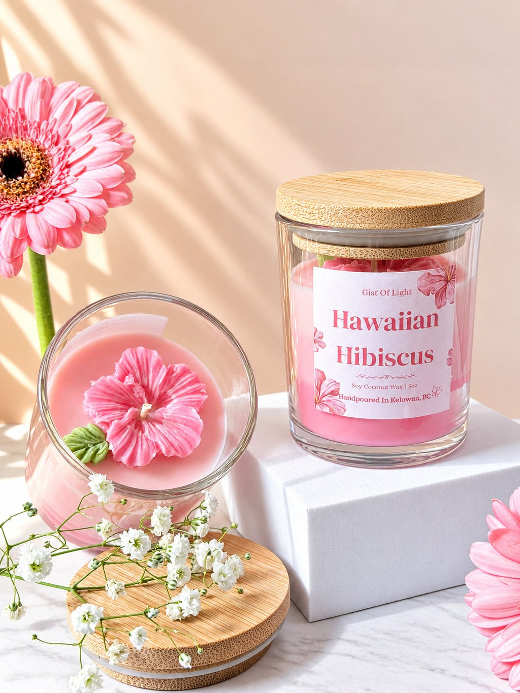 Hawaiian Hibiscus candle open beside a lidded jar, showing the pink wax flower and bamboo lid