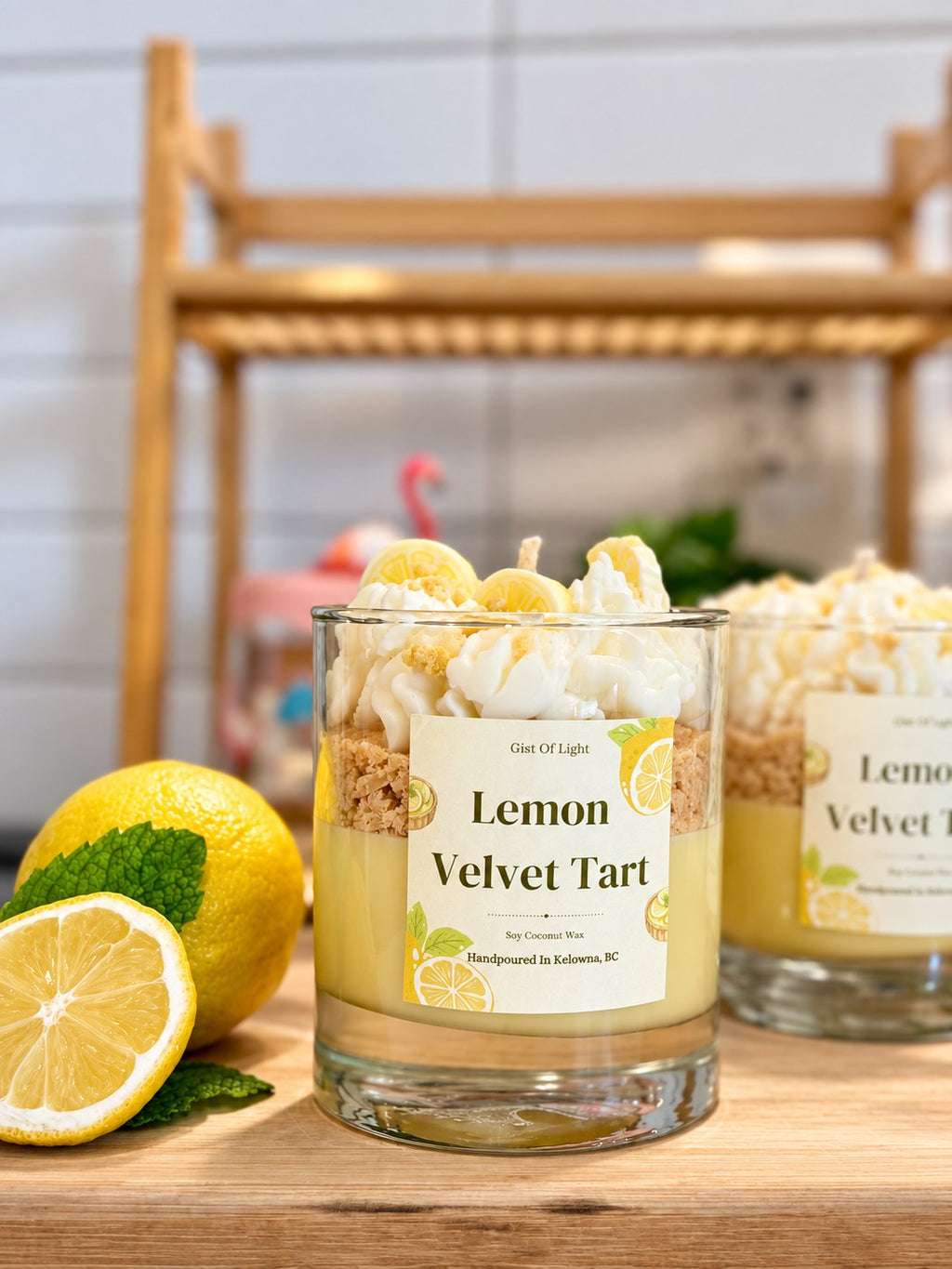 Two Lemon Velvet Tart dessert candles showing the lemon curd wax base and biscuit crumble layer