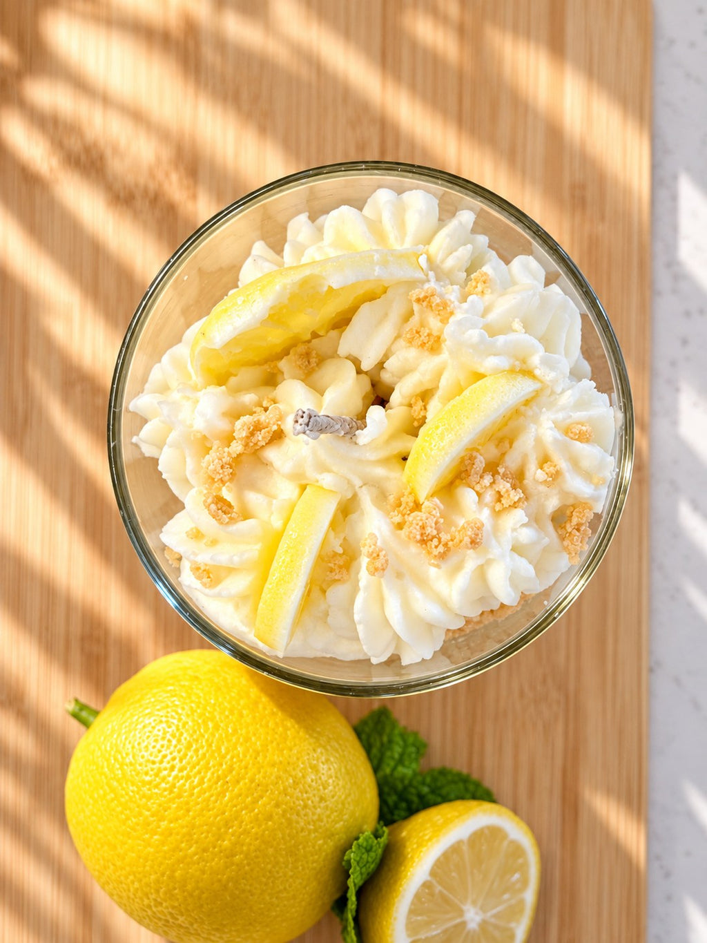 Lemon Velvet Tart candle from above showing the hand-piped whipped wax, moulded wax lemon wedges and golden crumble