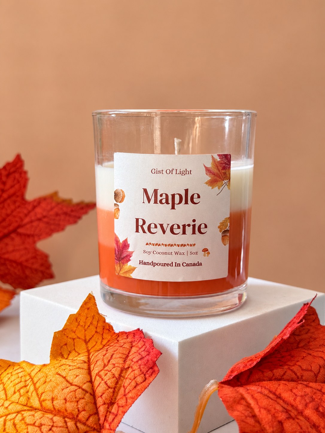 Maple Reverie candle on a white plinth showing the orange and white wax layers