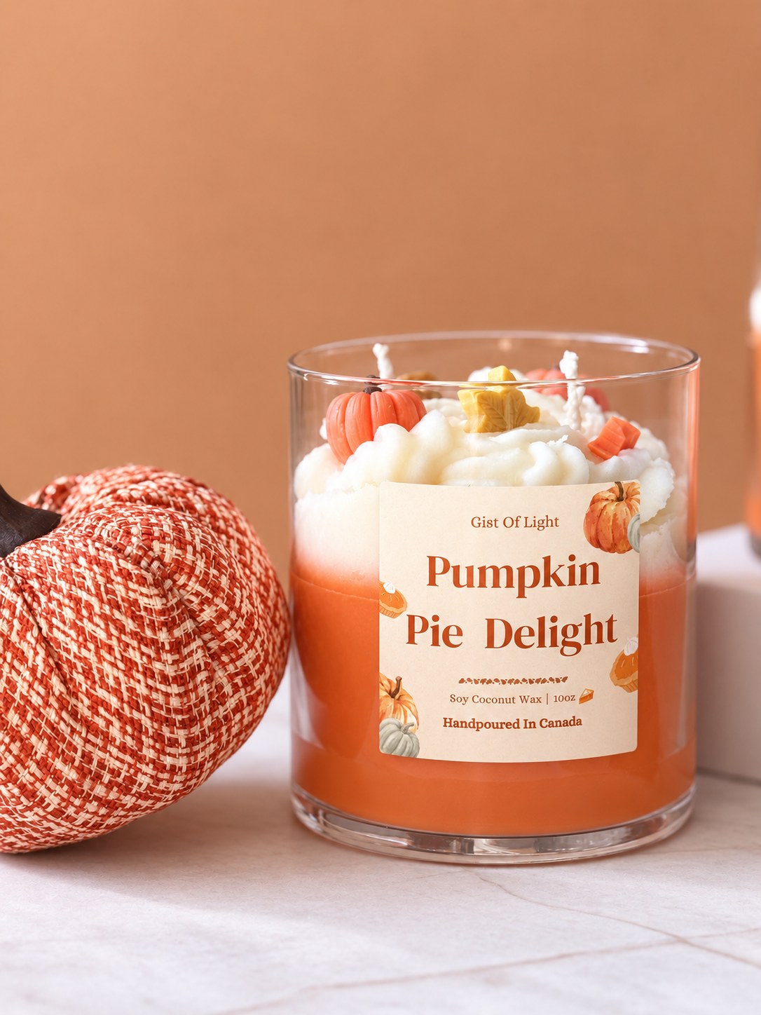 Pumpkin Pie Delight 10 oz dessert candle beside a woven pumpkin on a marble surface