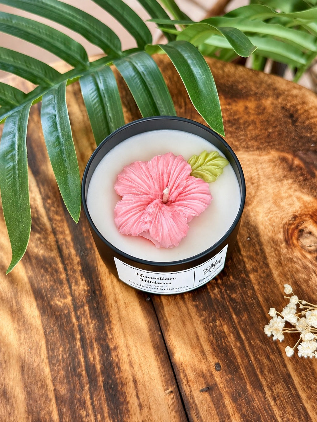 Hawaiian Hibiscus tin candle with a pink moulded wax hibiscus and green wax leaf