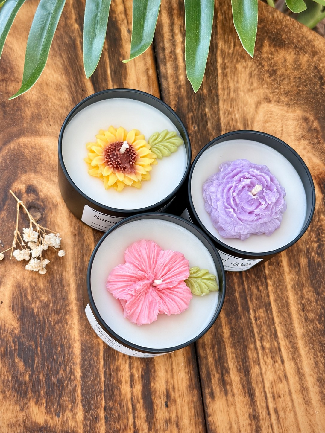 All three floral tin candle scents from above showing the sunflower, lavender and hibiscus wax flowers