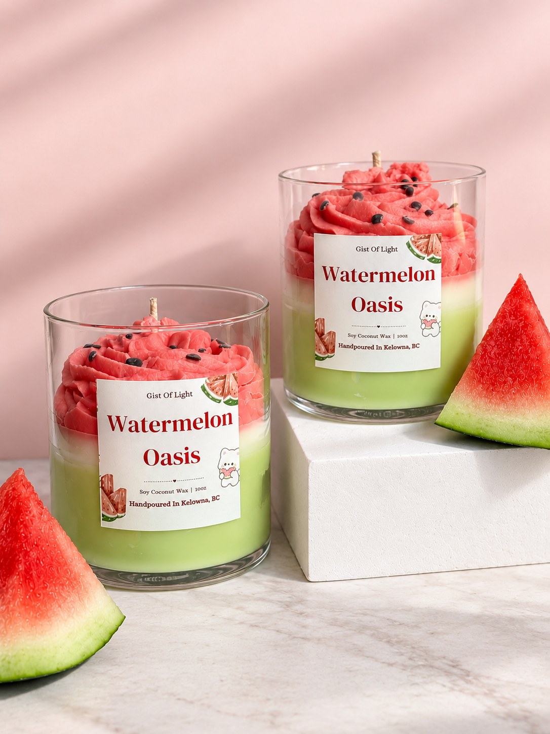 Two Watermelon Oasis summer candles on marble with fresh watermelon slices