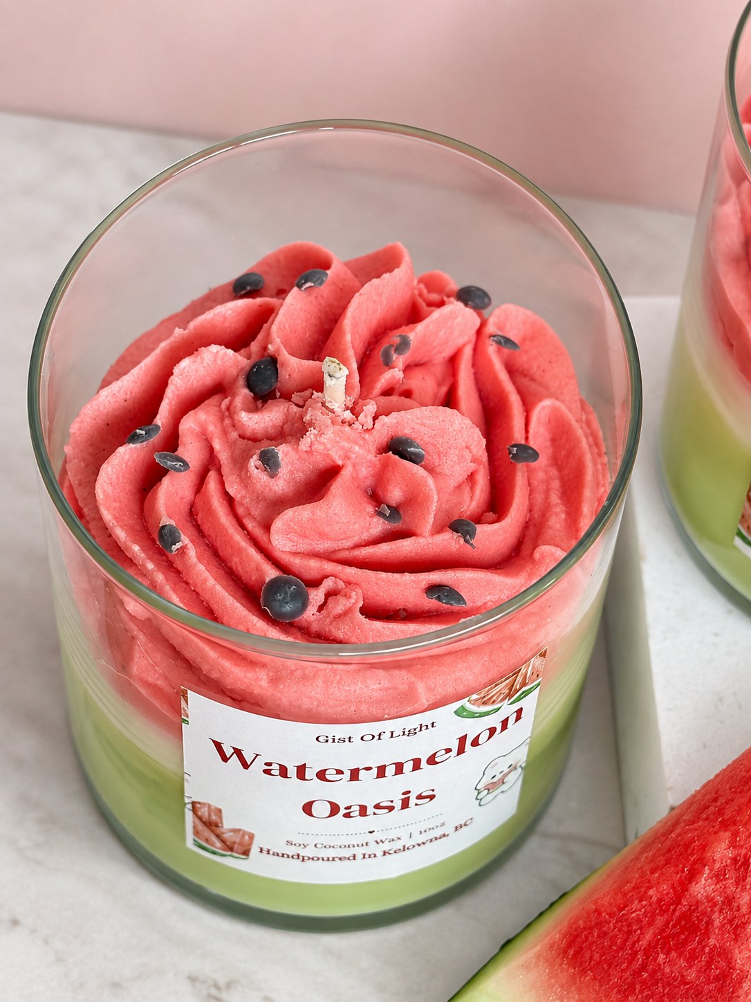 Close up of the Watermelon Oasis candle top with pink whipped wax and dark wax seeds