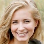 Smiling woman with blonde hair outdoors, representing positivity and light.