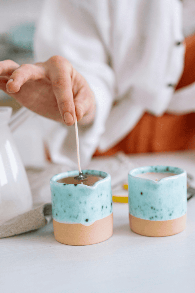 Hand lighting ceramic candle holder with blue glaze, cozy home decor.